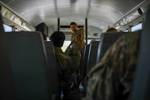 Airmen on a bus with luggage.