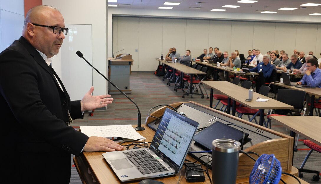 A man speaks to a group of REMs