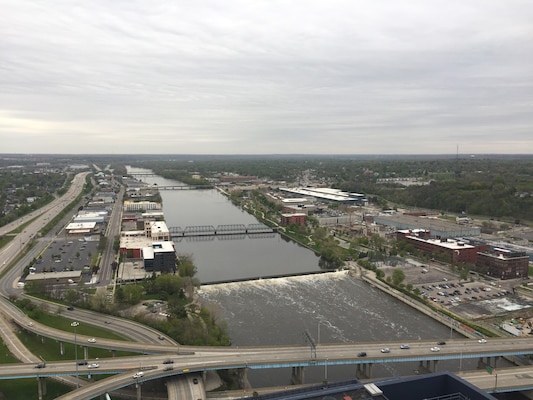 Aerial photograph showing water treatment or control infrastructure near river with adjacent parking and roadways