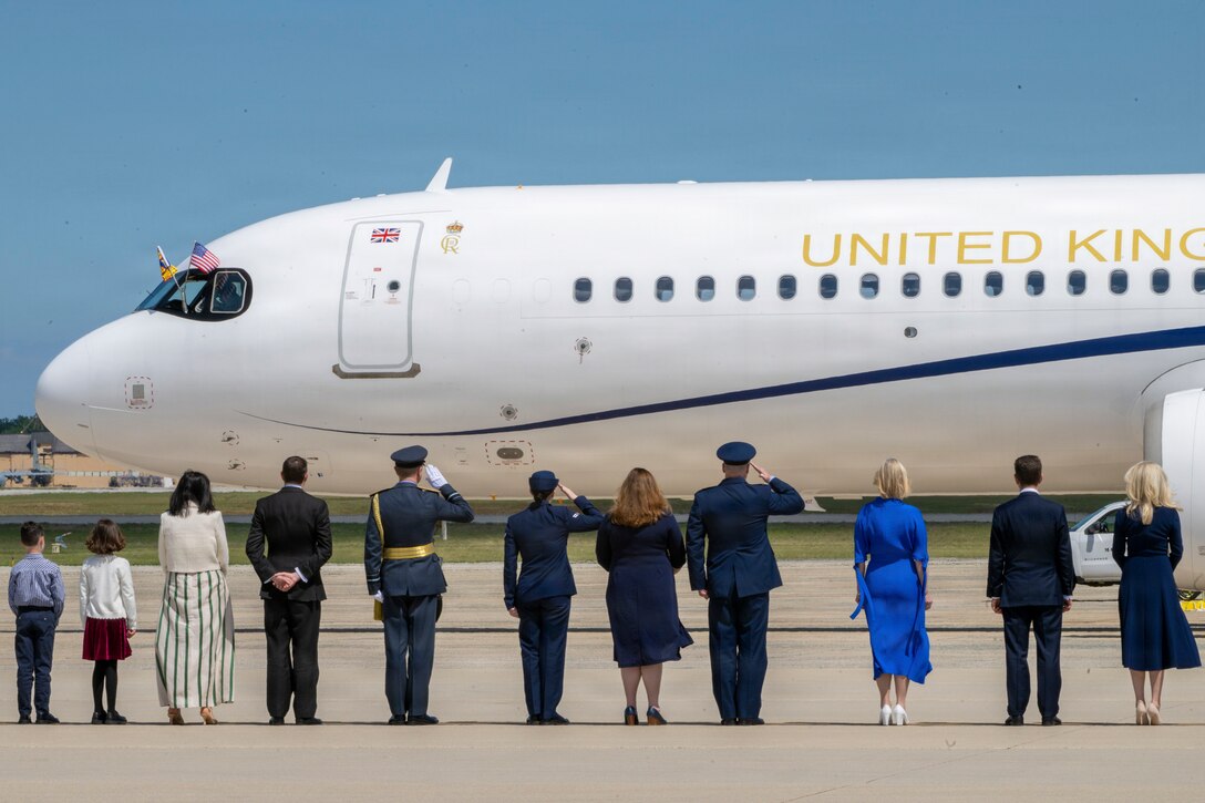 U.S. service members and Department of War leadership render salutes as a United Kingdom aircraft carrying Their Majesties of the United Kingdom of Great Britain and Northern Ireland.