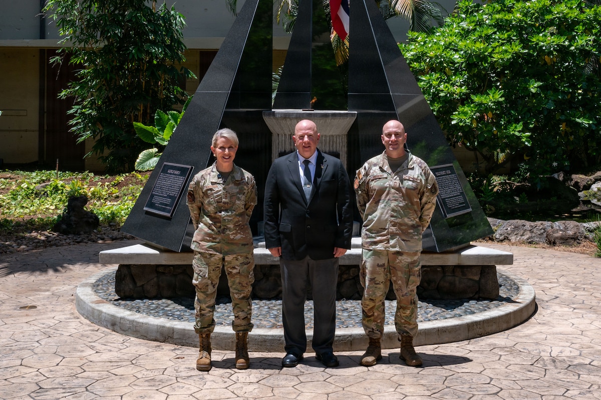 From left to right, a female serving as PACAF's Deputy Commander, Lt. Gen. Laura Lenderman, male dressed in a suit and is the senior advisor to the Secretary of War, Mr. Eric Geressy, and a male serving as PACAF's Senior Enlisted Leader to the Chief of Staff, Chief Master Sgt Shawn Andrews, stand centered in front of a monument with a flame that never extinguishes.