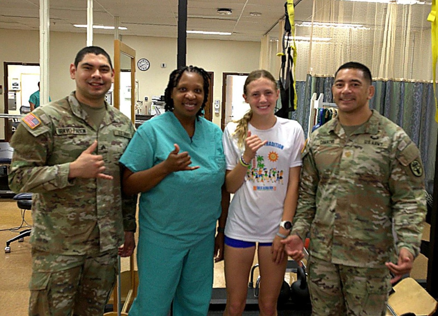 Sadie Kruger, center right, poses with members of Tripler Army Medical Center’s physical therapy team, Sgt. Jean Bravo-Pablon, left, physical therapy specialist; Margaret Thomas, center left, physical therapy assistant; and Maj. Roy Camacho, right, chief of physical therapy, April 17. With support from TAMC’s physical therapy services, Kreuger recovered from injury, won the Hawaii State Cross-Country title, was named as the Hawaii Gatorade Player of the Year for cross-country, and qualified to represent Team West at the Brooks Cross Country Nationals. (Defense Health Agency photos by Hugh Fleming)