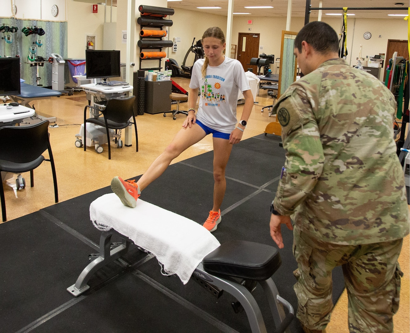 Sadie Kreuger, a student-athlete from Moanula High School, performs rehabilitation exercises with U.S. Army Sgt. Jean Bravo-Pablon, a physical therapist at Tripler Army Medical Center (TAMC), April 17. With support from TAMC’s physical therapy team, Kreuger recovered from injury, winning the Hawaii State Cross-Country title and earning recognition as Hawaii Gatorade Player of the Year for cross-country and qualifying to represent Team West at the Brooks Cross Country Nationals. (Defense Health Agency photos by Hugh Fleming)