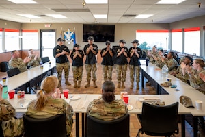 A group of uniformed personnel claps during a training event.