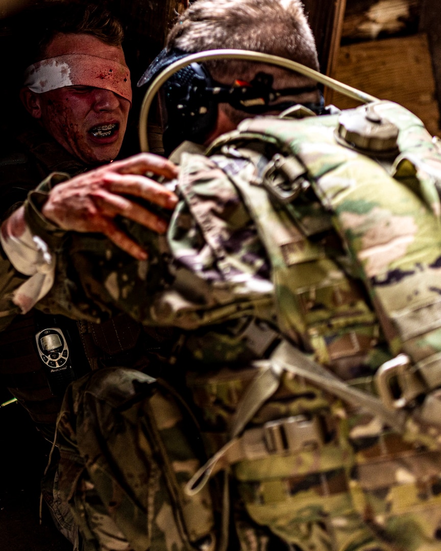 Capt. Mark Wrenn, Oklahoma Battlefield Resilience Camp creator and officer in charge, acts as a simulated hostage while Soldiers practice iCOVER techniques to manage an acute stress and injury scenario during the Oklahoma Battlefield Resilience Camp at Camp Gruber Training Center near Braggs, Okla, April 23, 2026. The training emphasizes integrating resilience and behavioral health skills into squad-level tactics, ensuring Soldiers remain lethal, cohesive and prepared to respond to complex missions at home and abroad. (Oklahoma National Guard photo by Sgt. Haden Tolbert)