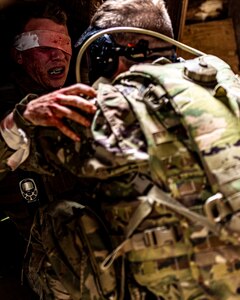 Capt. Mark Wrenn, Oklahoma Battlefield Resilience Camp creator and officer in charge, acts as a simulated hostage while Soldiers practice iCOVER techniques to manage an acute stress and injury scenario during the Oklahoma Battlefield Resilience Camp at Camp Gruber Training Center near Braggs, Okla, April 23, 2026. The training emphasizes integrating resilience and behavioral health skills into squad-level tactics, ensuring Soldiers remain lethal, cohesive and prepared to respond to complex missions at home and abroad. (Oklahoma National Guard photo by Sgt. Haden Tolbert)