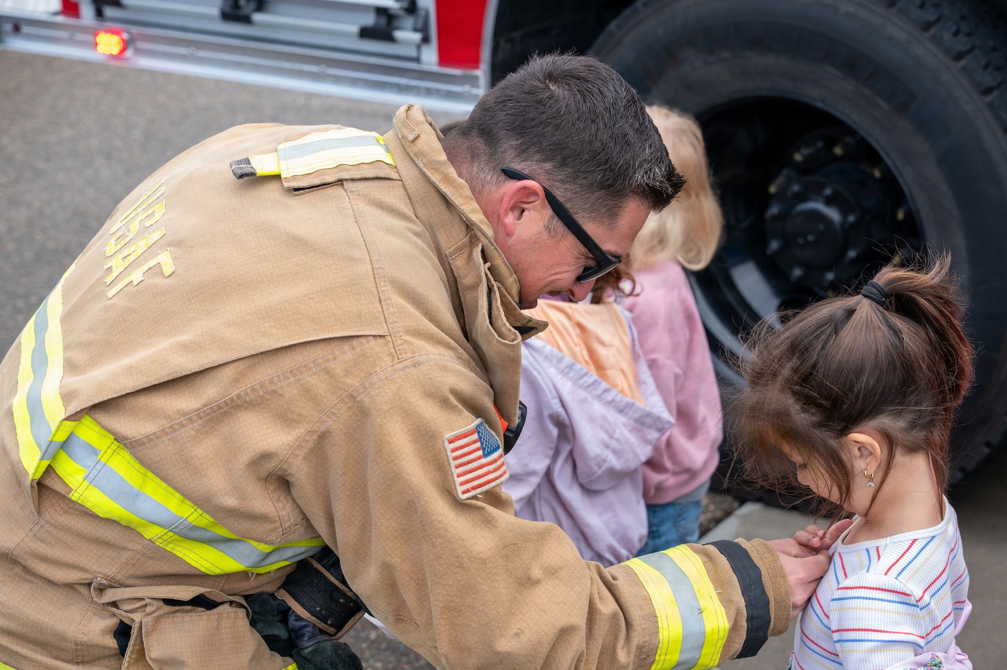 a firefighter places a sticker on a child's shirt
