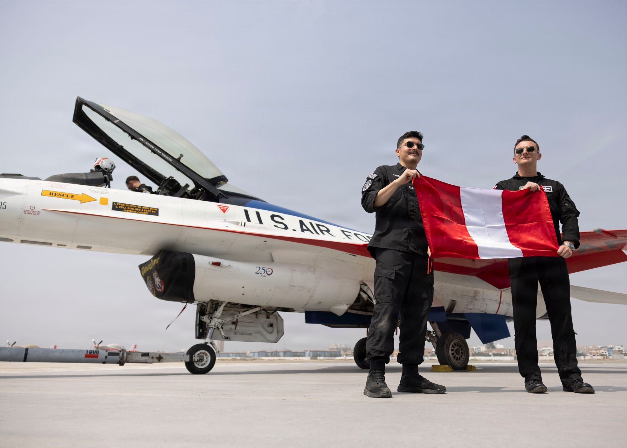 U.S. Air Force Maj. Taylor “FEMA” Hiester, F-16 Viper Demonstration Team commander and pilot, right, and Staff Sgt. Steven Cardo, F-16 Viper Demonstration Team public affairs specialist, display the Peruvian flag during the Peru Airshow at Las Palmas Air Base, Peru, April 25, 2026. The display recognizes the partnership between the United States and Peru and highlights U.S. Air Force participation in the international event. (U.S. Air Force photo by Staff Sgt. Lauren Diaz)