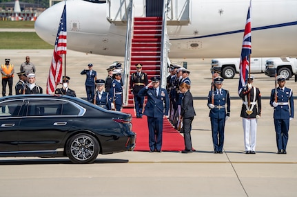 U.S. Air Force Col. Christopher M. Robinson, commander of the 89th Airlift Wing, renders a salute to Their Majesties of the United Kingdom of Great Britain and Northern Ireland.