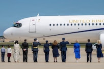 U.S. service members and Department of War leadership render salutes as a United Kingdom aircraft carrying Their Majesties of the United Kingdom of Great Britain and Northern Ireland.