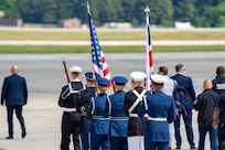 U.S. service members with an armed forces color guard carry the U.S. flag and the flag of the United Kingdom.