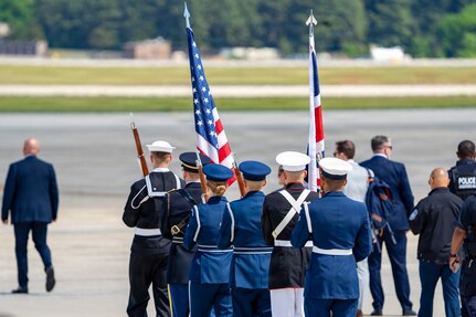 U.S. service members with an armed forces color guard carry the U.S. flag and the flag of the United Kingdom.