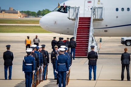 U.S. service members with an armed forces full honor cordon and Department of War security personnel stand in front of a United Kingdom aircraft.