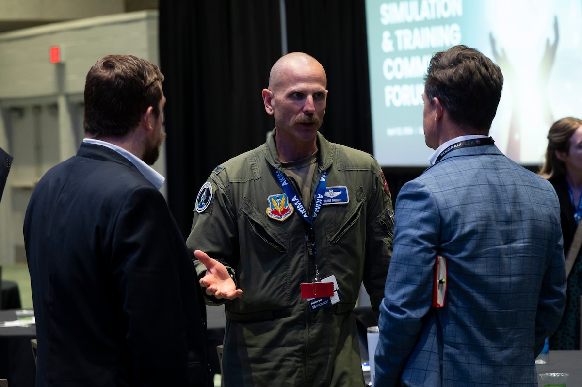 Three men standing, talking.