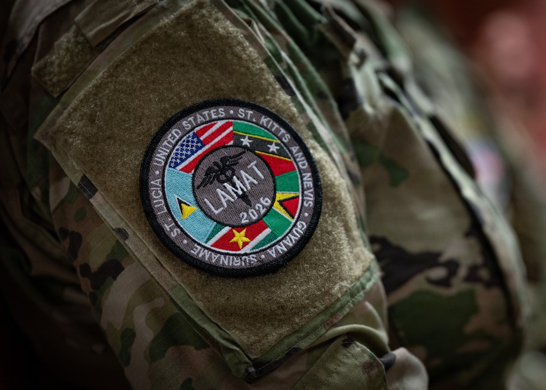 A U.S. Airman attends the closing ceremony of the Lesser Antilles Medical Assistance Team (LAMAT) 2026 mission in Paramaribo, Suriname, April 23, 2026. The LAMAT 2026 team collectively treated a total of 2,000 patients, provided over 3,000 eyeglasses and conducted 432 knowledge exchange hours together with their counterparts in Suriname. (U.S. Air Force photo by Staff. Sgt. Madeline Herzog)