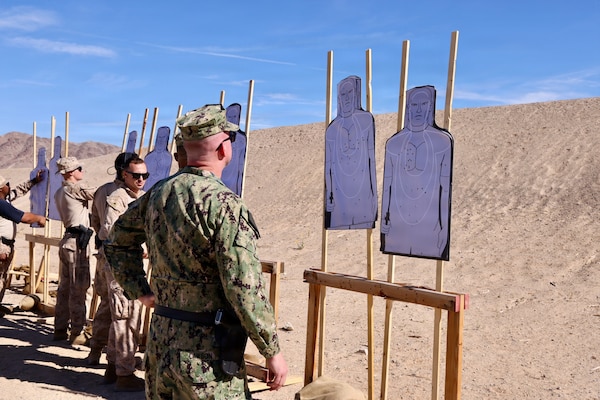 mdr. William “Bill” Lawson (right), acting executive officer, assigned to Navy Medicine Readiness and Training Command Twentynine Palms, reviews his target after firing the M9 service pistol during training at Marine Corps Air Ground Combat Center Twentynine Palms, Calif., March 26, 2026. (U.S. Navy photo by Christopher Jones, NMRTC/NH Twentynine Palms public affairs officer)