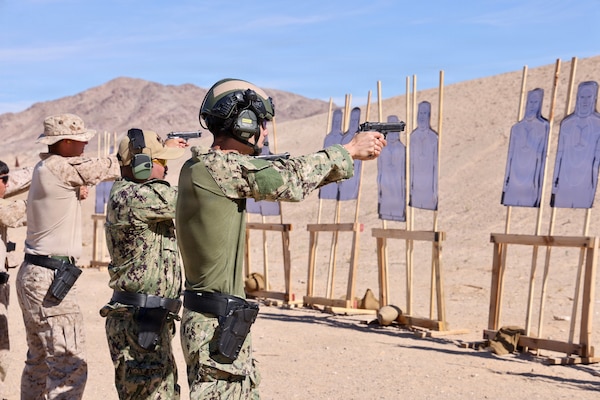 Hospital Corpsman 3rd Class Ayden Z. Massey (right) and Lt. j.g. Duane A. Daquioag (center), both assigned to Navy Medicine Readiness and Training Command Twentynine Palms, fire alongside Marines with the M9 service pistol during training at Marine Corps Air Ground Combat Center Twentynine Palms, Calif., March 26, 2026. (U.S. Navy photo by Christopher Jones, NMRTC/NH Twentynine Palms public affairs officer)