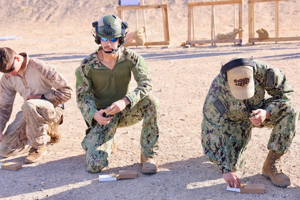 Hospital Corpsman 3rd Class Ayden Z. Massey (center) and Lt. j.g. Duane A. Daquioag (right), both assigned to Navy Medicine Readiness and Training Command Twentynine Palms, reload the M9 service pistol during training at Marine Corps Air Ground Combat Center Twentynine Palms, Calif., March 26, 2026. (U.S. Navy photo by Christopher Jones, NMRTC/NH Twentynine Palms public affairs officer)