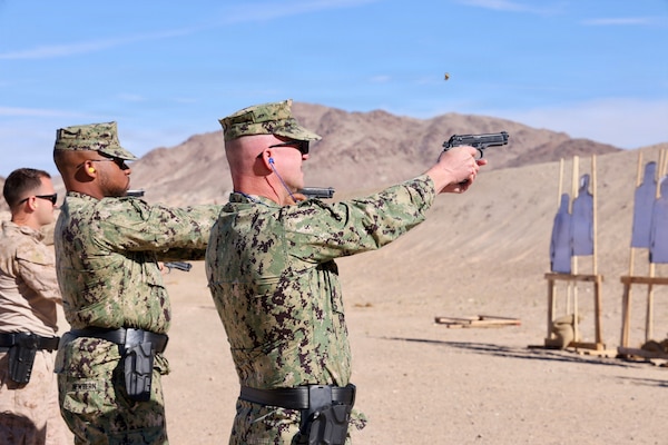 Cmdr. William “Bill” Lawson (right), acting executive officer, and Hospital Corpsman 2nd Class Aijalon Newbern (center), both assigned to Navy Medicine Readiness and Training Command Twentynine Palms, fire alongside Marines with the M9 service pistol during training at Marine Corps Air Ground Combat Center Twentynine Palms, Calif., March 26, 2026. (U.S. Navy photo by Christopher Jones, NMRTC/NH Twentynine Palms public affairs officer)
