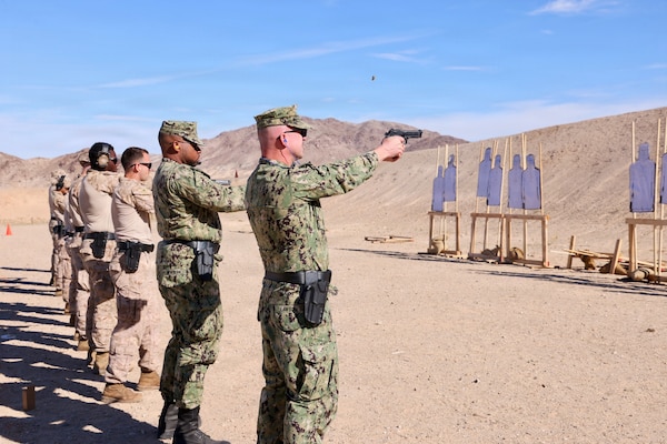 Cmdr. William “Bill” Lawson (right), acting executive officer, and Hospital Corpsman 2nd Class Aijalon Newbern (center right), both assigned to Navy Medicine Readiness and Training Command Twentynine Palms, fire alongside Marines with the M9 service pistol during training at Marine Corps Air Ground Combat Center Twentynine Palms, Calif., March 26, 2026. (U.S. Navy photo by Christopher Jones, NMRTC/NH Twentynine Palms public affairs officer)