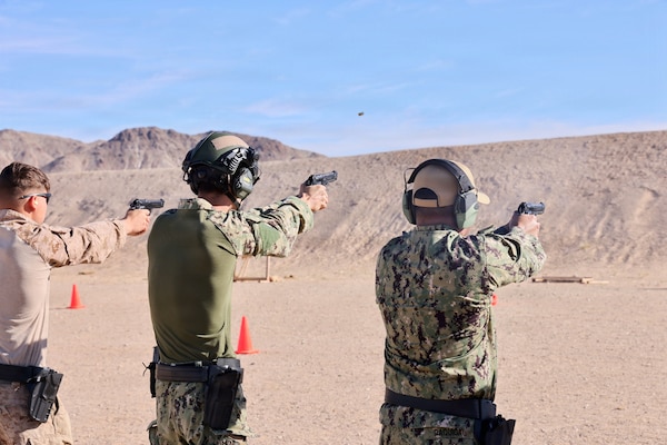 Hospital Corpsman 3rd Class Ayden Z. Massey (center) and Lt. j.g. Duane A. Daquioag (right), both assigned to Navy Medicine Readiness and Training Command Twentynine Palms, fire the M9 service pistol during training at Marine Corps Air Ground Combat Center Twentynine Palms, Calif., March 26, 2026. (U.S. Navy photo by Christopher Jones, NMRTC/NH Twentynine Palms public affairs officer)