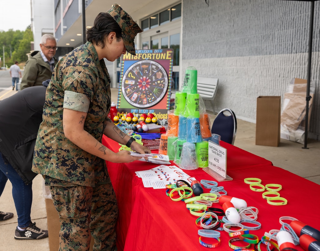U.S. Marine Corps Lance Cpl. Gabrielle Angeles, a military police officer with Marine Corps Base Quantico Provost Marshall Office, prepares a table for the Drug Enforcement Administration Drug Take Back Program at the Marine Corps Exchange on MCB Quantico, Virginia, April 27, 2026. This program is hosted by the DEA to provide a safe, convenient, and responsible means of disposing expired and unused prescription medications. (U.S. Marine Corps photo by Sgt. Chancellor Reynolds)