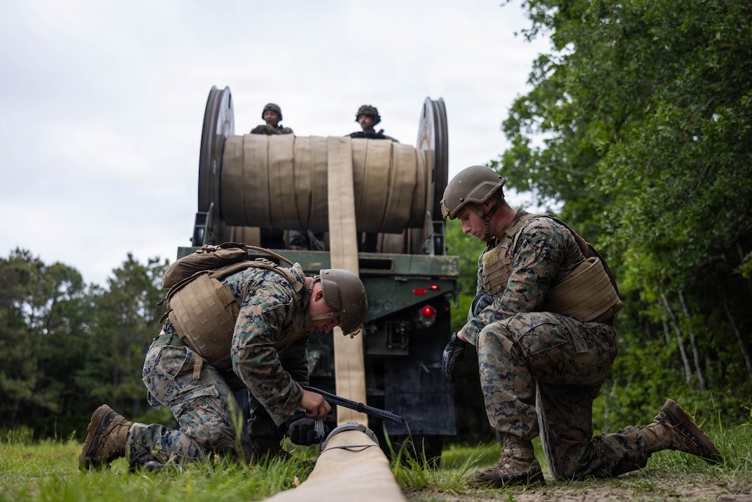 U.S. Marine Corps Lance Cpl. Tristan Whitson, left, and Lance Cpl. Cody Goerig, both expeditionary fuels technicians with 8th Engineer Support Battalion, Combat Logistics Regiment 27, 2nd Marine Logistics Group, unclip a hose during an air-delivered ground refueling site set up as part of a large multi-modal field exercise at Marine Corps Base Camp Lejeune, North Carolina, April 27, 2026. The purpose of this exercise is to train and evaluate the platoon's ability to provide distributed and expeditionary class III resupply from an expeditionary advanced base. Whitson is a native of Georgia. Goerig is a native of Florida. (U.S. Marine Corps photo by Sgt. Alfonso Livrieri)