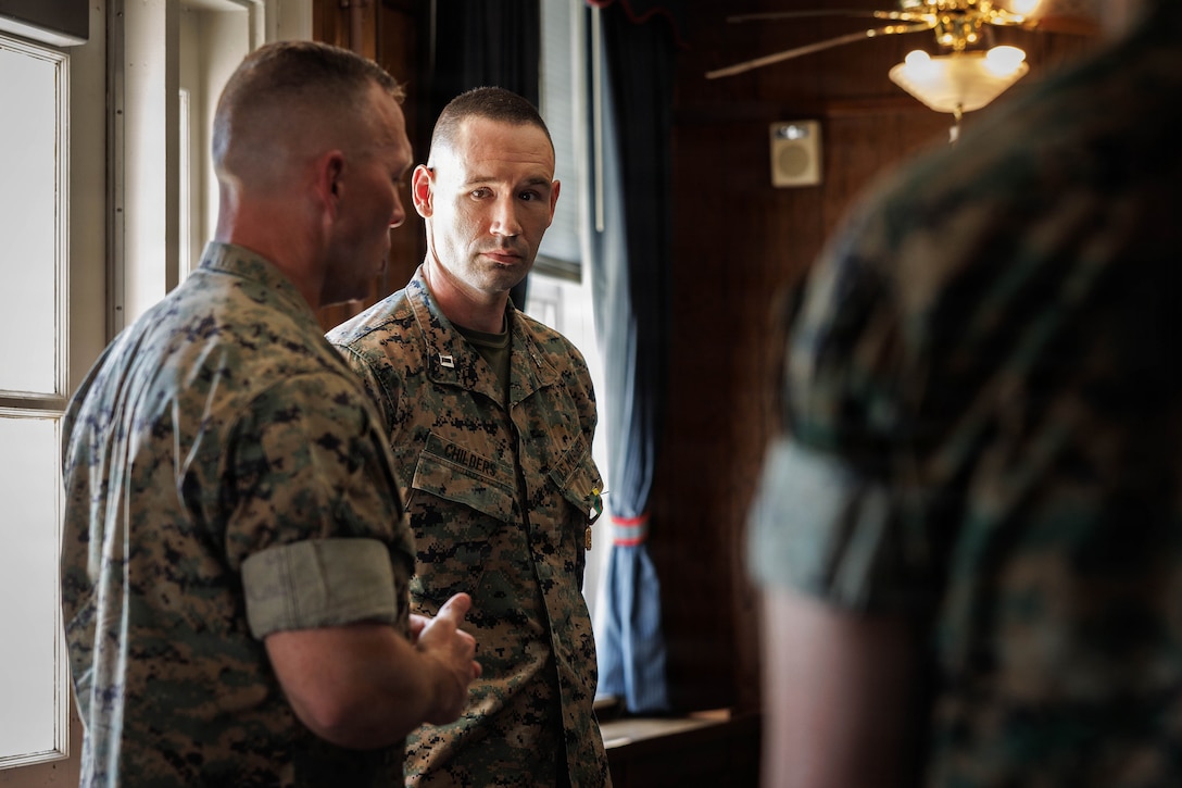 U.S. Marine Corps Lt. Col. Denver Edick, the commanding officer of Security Battalion, left, addresses the audience during Capt. Benjamin Childers, a victims’ legal counsel with Marine Corps Base Quantico’s Law Center, right, award ceremony at Lejeune Hall on MCB Quantico, April 14, 2025. Childers was awarded the Navy and Marine Corps Achievement Medal and became the recipient of the office of Attorney General Jay Jones 2026 Unsung Hero Award. Childers acted immediately to secure life-preserving intervention for a client, demonstrating correct judgment and moral courage. He was recognized for his service to victims of crime across the commonwealth of Virginia through advocacy and dedication while serving as a victims’ legal counsel, representing more than 60 crime victims and safeguarding privacy rights through decisive litigation in multiple courts-martials. (U.S. Marine Corps Photo by Cpl. Harleigh Faulk)