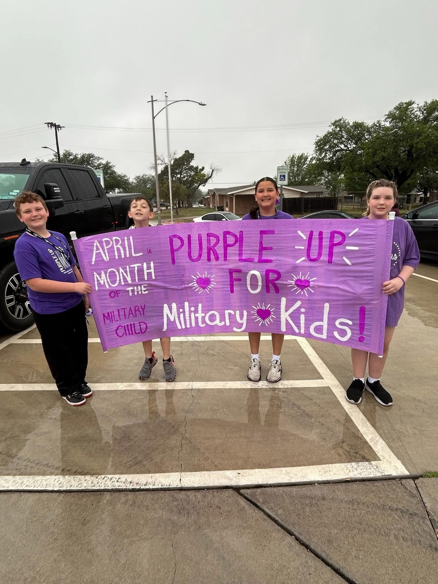 Students from Roberto “Bobby” Barrera Elementary School holds up a Month of the Military Child banner during the Purple Parade at Laughlin Air Force Base, Texas, April 15, 2026. The Department of War observes every April as Month of the Military Child to recognize children who grow up in military families. (Courtesy photo)