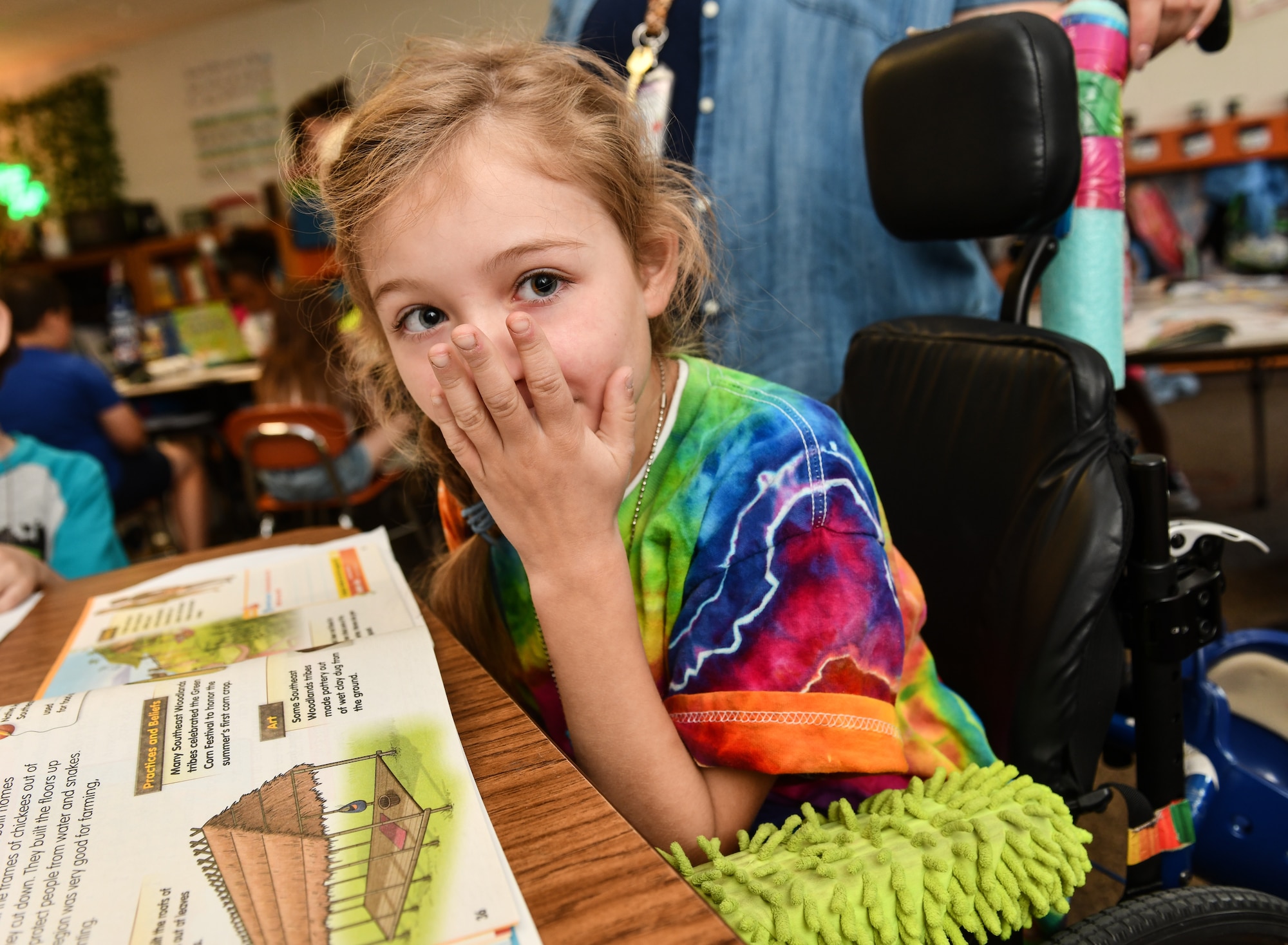 Hannah giggles at a joke during reading time at Leonard Lawrence Elementary school in Bellevue, Neb. on April 22, 2026. Once considered non-verbal, Hannah has had tremendous growth during the past three years, and considers reading one of her favorite activities. (U.S. Air Force photo by Chad Watkins)