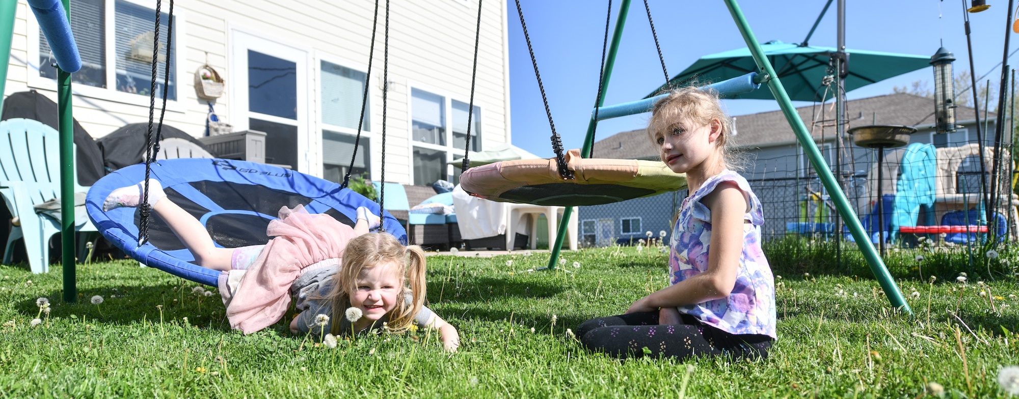Hazel and Hannah play on swings in their backyard on April 24, 2026. Hazel is Hannah's little sister, and favorite person. (U.S. Air Force photo by Chad Watkins)