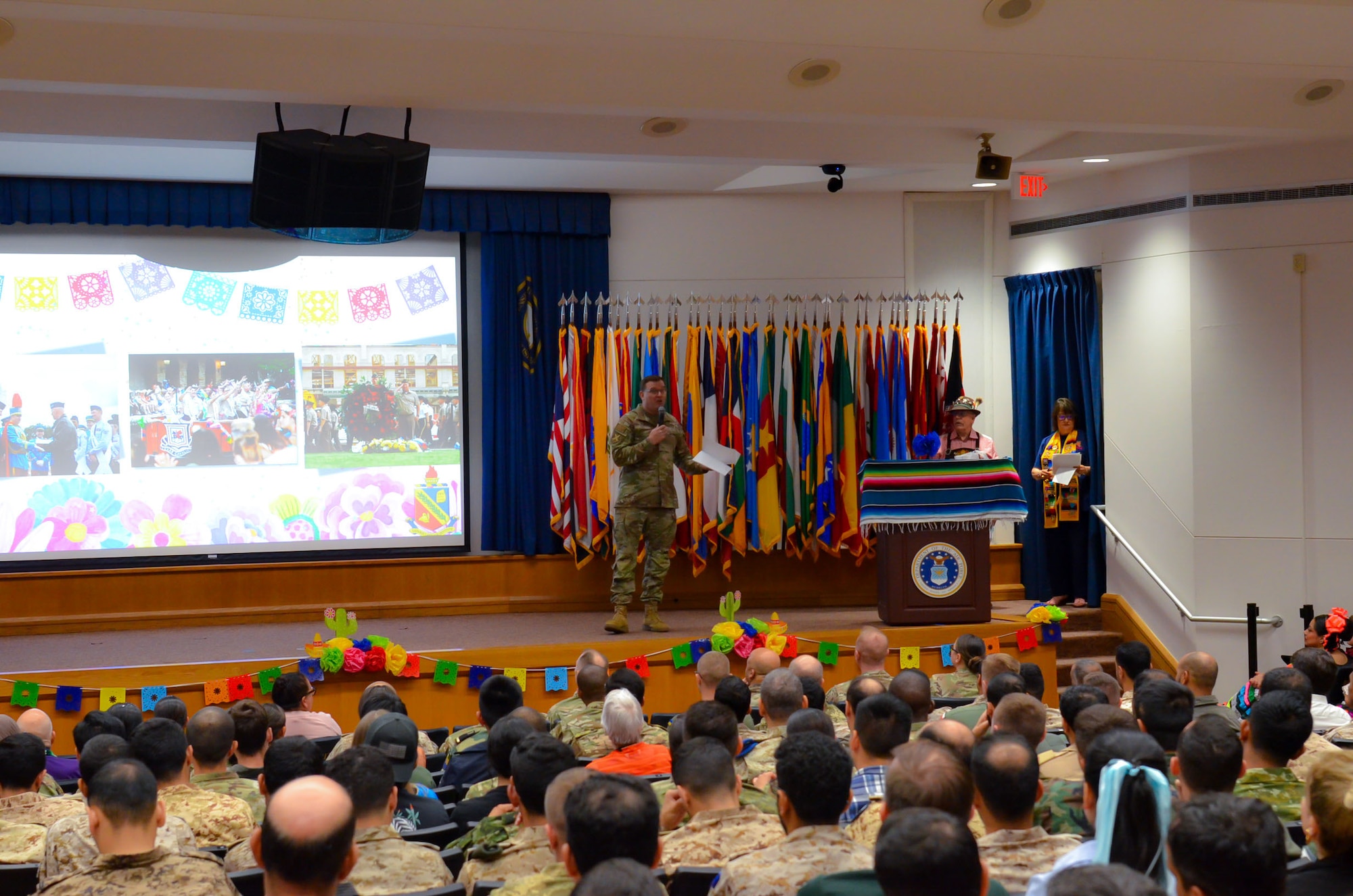 Defense Language Institute English Language Center students and staff are welcomed by commanding officer Col. Dustin Hart and instructors Emily Purificato and Jim Cherry at the Fiesta Showcase in San Antonio, Texas, April 15, 2026. DLIELC builds security cooperation through English language training and cultural immersion for international military partners and pre-basic combat trainees in the U.S. Army and Coast Guard. (U.S. Air Force photo by Agnes Koterba)