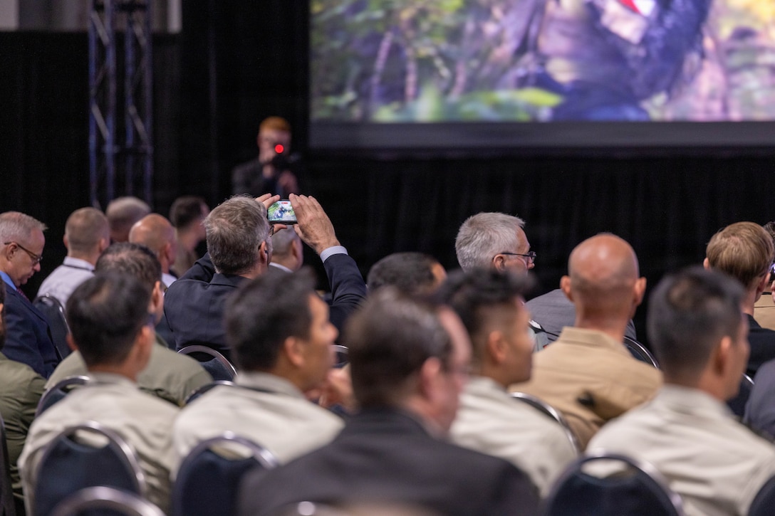An audience member captures the Ground Combat Element 2040 presentation screen during Modern Day Marine 2026, Walter E. Washington Convention Center, Washington, DC, April 29, 2026. Modern Day Marine brings together representatives from military, industry and government to collaborate in shaping the future of the United States Marine Corps. Through the interactions taking place at Modern Day Marine, the Corps is able to engage, educate and increase understanding of the Marine Corps' contributions to the National Defense Strategy. (U.S. Marine Corps photo by Cpl. Carlina Holland)