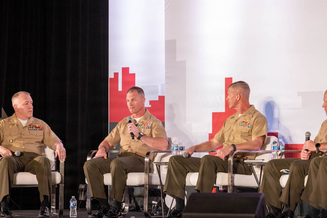 U.S. Marine Corps Col. Erick Clark, left, Maj. Gen. Kyle Ellison, middle, and Maj. Gen. John Jarrard, right, gives a speech during Modern Day Marine 2026, Walter E. Washington
Convention Center, Washington, DC, April 29, 2026. Modern Day Marine brings
together representatives from military, industry and government to collaborate in
shaping the future of the United States Marine Corps. Through the interactions taking
place at Modern Day Marine, the Corps is able to engage, educate and increase
understanding of the Marine Corps' contributions to the National Defense Strategy.
(U.S. Marine Corps photo by Cpl. Carlina Holland)