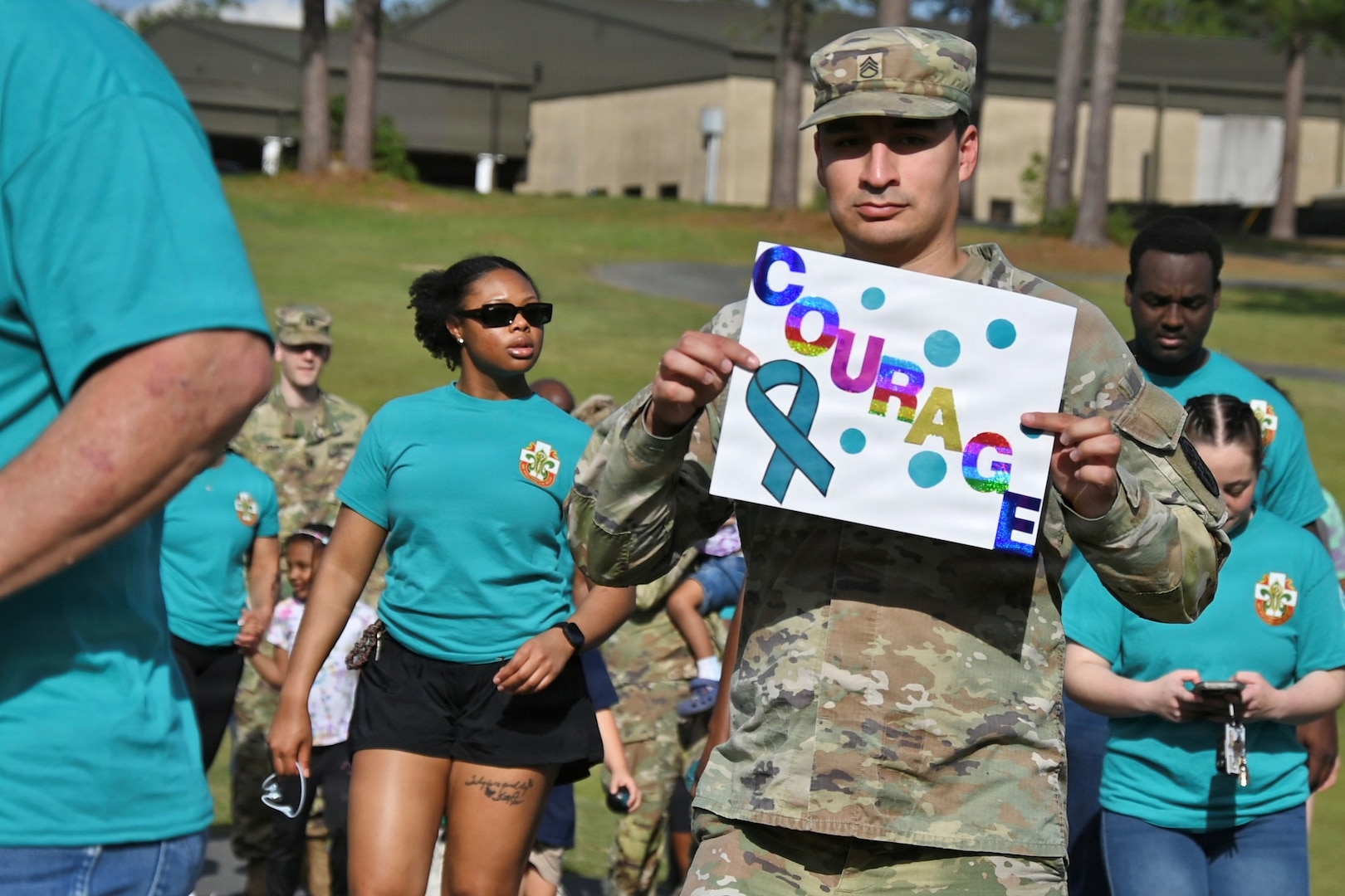 A Soldier holds a sign at a community wide walk against sexual assault.