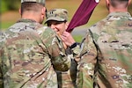 New Medical Company commander takes the guidon from the hospital commander during a change of command ceremony.