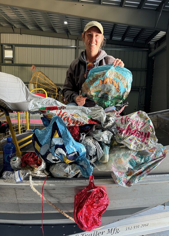 Jessica “Skippy” Martin, an invasive species biologist, stands with 28 balloons collected during a three-hour cleanup effort near Julian Keen, Florida, April 22, 2026. The volume of debris highlights the scale of pollution affecting Lake Okeechobee and surrounding ecosystems. (U.S. Army Corps of Engineers photo)