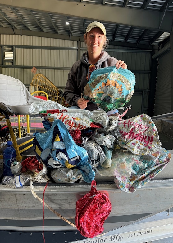 Jessica “Skippy” Martin, an invasive species biologist, stands with 28 balloons collected during a three-hour cleanup effort near Julian Keen, Florida, April 22, 2026. The volume of debris highlights the scale of pollution affecting Lake Okeechobee and surrounding ecosystems. (U.S. Army Corps of Engineers photo)