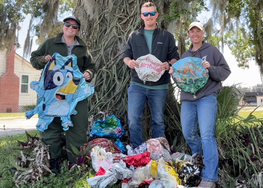 From left, Megan Parsons, Lee Martin and Jessica “Skippy” Martin pose with balloons collected during a cleanup effort near Julian Keen, Florida, April 22, 2026. The team recovered 28 balloons in three hours, demonstrating the widespread impact of litter in waterways. (U.S. Army Corps of Engineers photo)