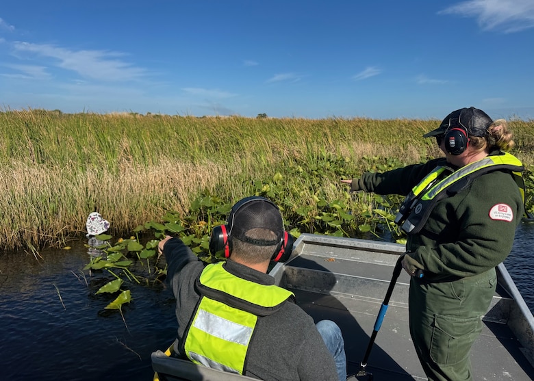 Megan Parsons, left, and Lee Martin identify a floating balloon while conducting a cleanup by airboat on Lake Okeechobee, Florida, April 22, 2026. Balloon debris is a common pollutant that can harm aquatic environments and wildlife. (U.S. Army Corps of Engineers photo)