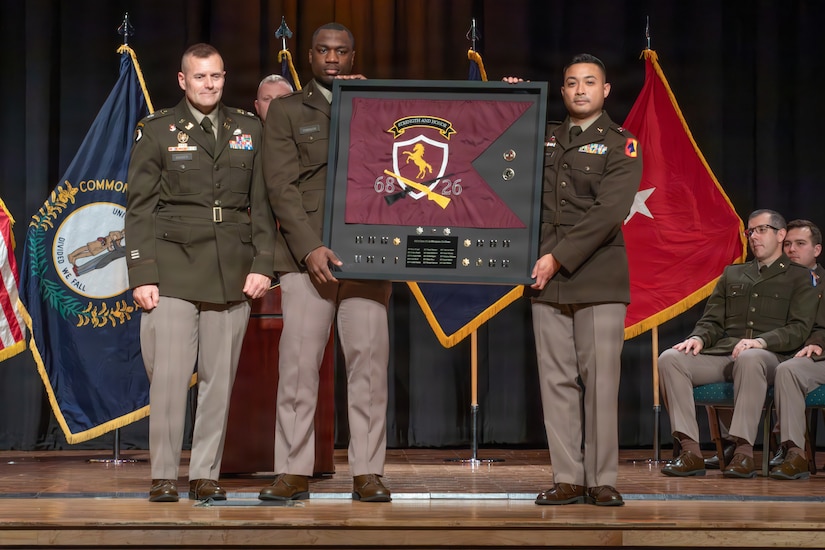 Officer Candidates Jason Robinson and Elrad Malunay present their class guidon to Lt. Col. John Barger, commander of Kentucky's 238th Regiment, during the Officer Candidate School Class 68-26 graduation at the Kentucky State University David H. Bradford Hall Auditorium in Frankfort, Kentucky, April 18, 2026.
