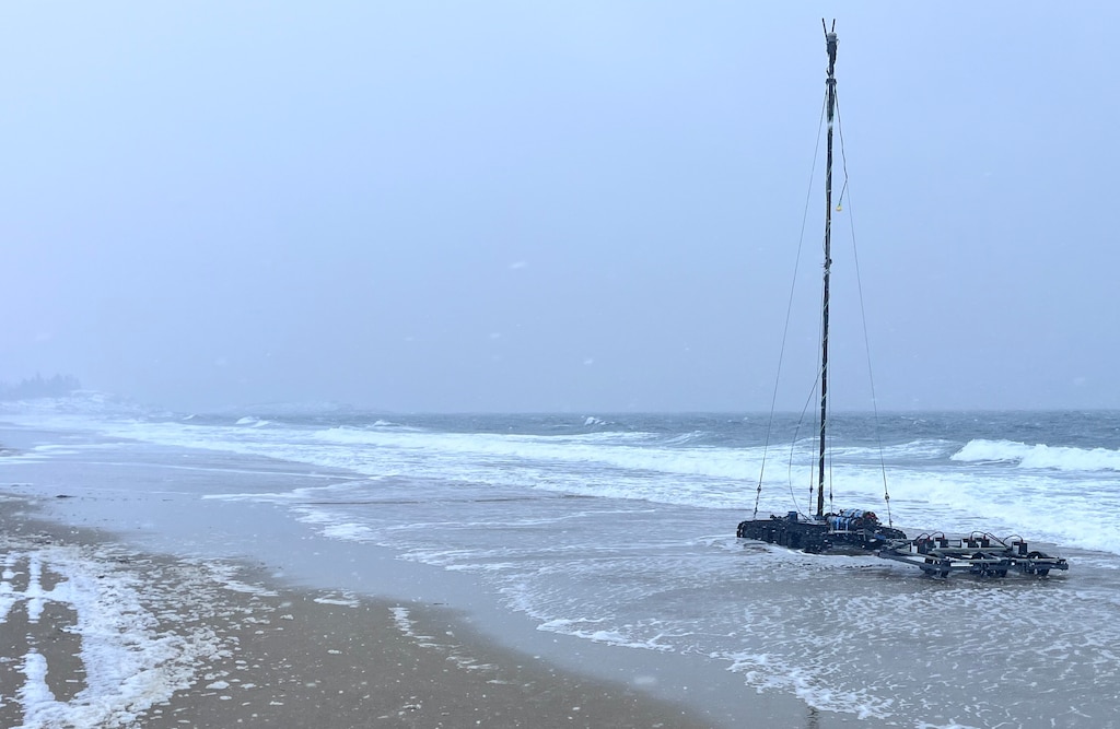 A cold winter Maine shoreline with a robotic crawler towing a  m-APEX metal detector.