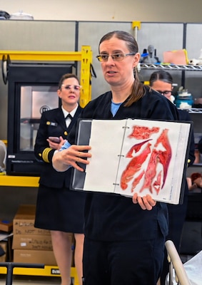 260409-N-IX644-1033 (April 9, 2026) SILVER SPRING, Md. Betsy Weissbord, a medical illustrator at the Hybrid Lab Immersive Environment, presents a book of medical temporary tattoos for high-fidelity medical training during the Inaugural Navy Medicine Education Leadership Summit in Silver Spring, Maryland. The summit aims to provide academic leaders with a unique, high-level overview of the strategic challenges and groundbreaking opportunities within Navy Medicine for future military healthcare professionals. The Navy Medicine Enterprise's 44,000+ talented and ready forces optimize health readiness, deliver quality healthcare, and provide global expeditionary medical support to warfighters. (U.S. Navy photo by Mass Communication Specialist 2nd Class Sasha Ambrose)