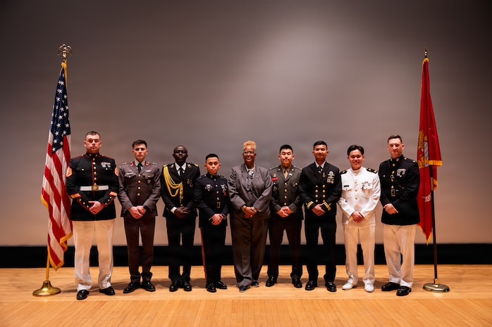 U.S. Marines and foreign military graduates with Basic Officer Course 5-25, Company E, The Basic School, Training Command, pose for a photo after a graduation ceremony at Marine Corps Base Quantico, Virginia, March 13, 2026. TBS trains and educates newly commissioned or appointed officers in the high standards of professional knowledge, esprit de corps, and leadership to prepare them for duty as company-grade officers. (U.S. Marine Corps photo by Cpl. Joshua Barker)