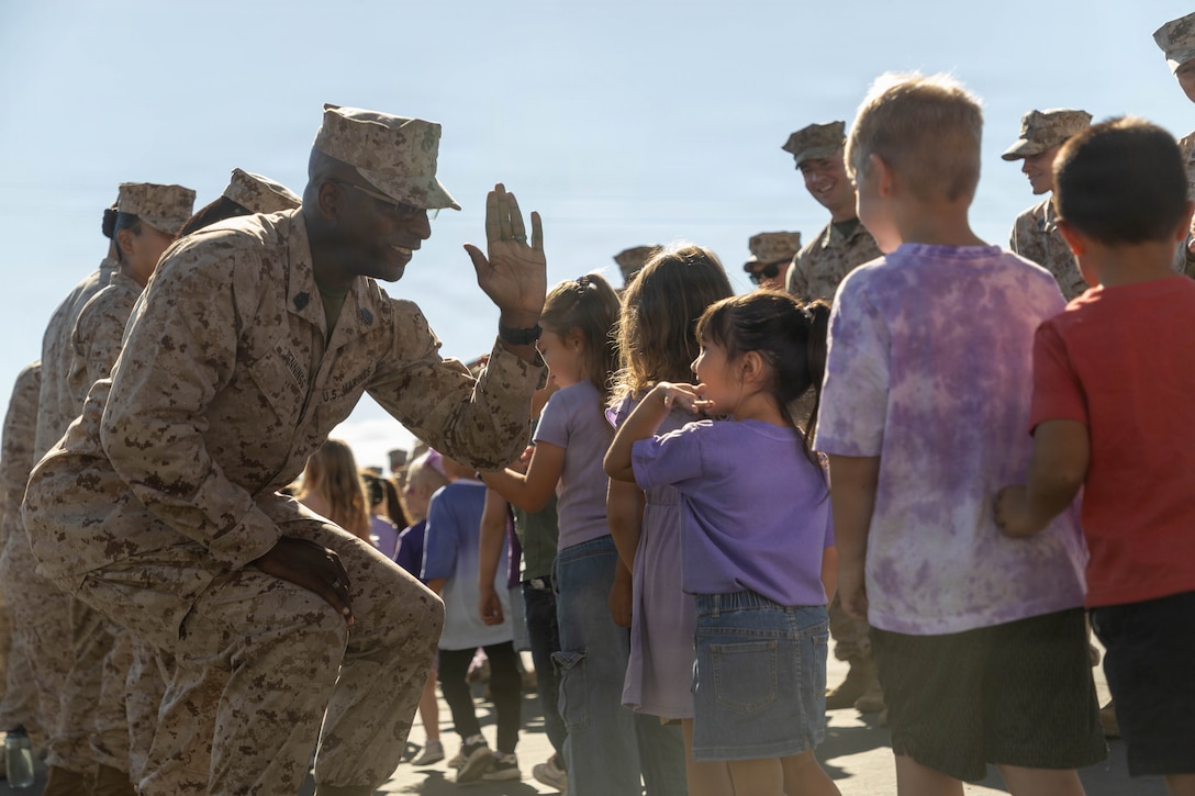U.S. Marine Corps Sgt. Maj. Trevor Jennings, a New York native, Command Senior Enilisted Leader of Marine Corps Communication Electronics School, Training Command,Training and Education Command, high fives a child at a Month of the Military Child parade at Marine Corps Air Ground Combat Center, Twentynine Palms, California, April 10, 2026. The showcase was held in recognition of the Month of the Military Child which honors the important role children play in supporting service members and highlights the unique challenges of growing up in a military family. (U.S. Marine Corps photo by Lance Cpl. Jose Perez)