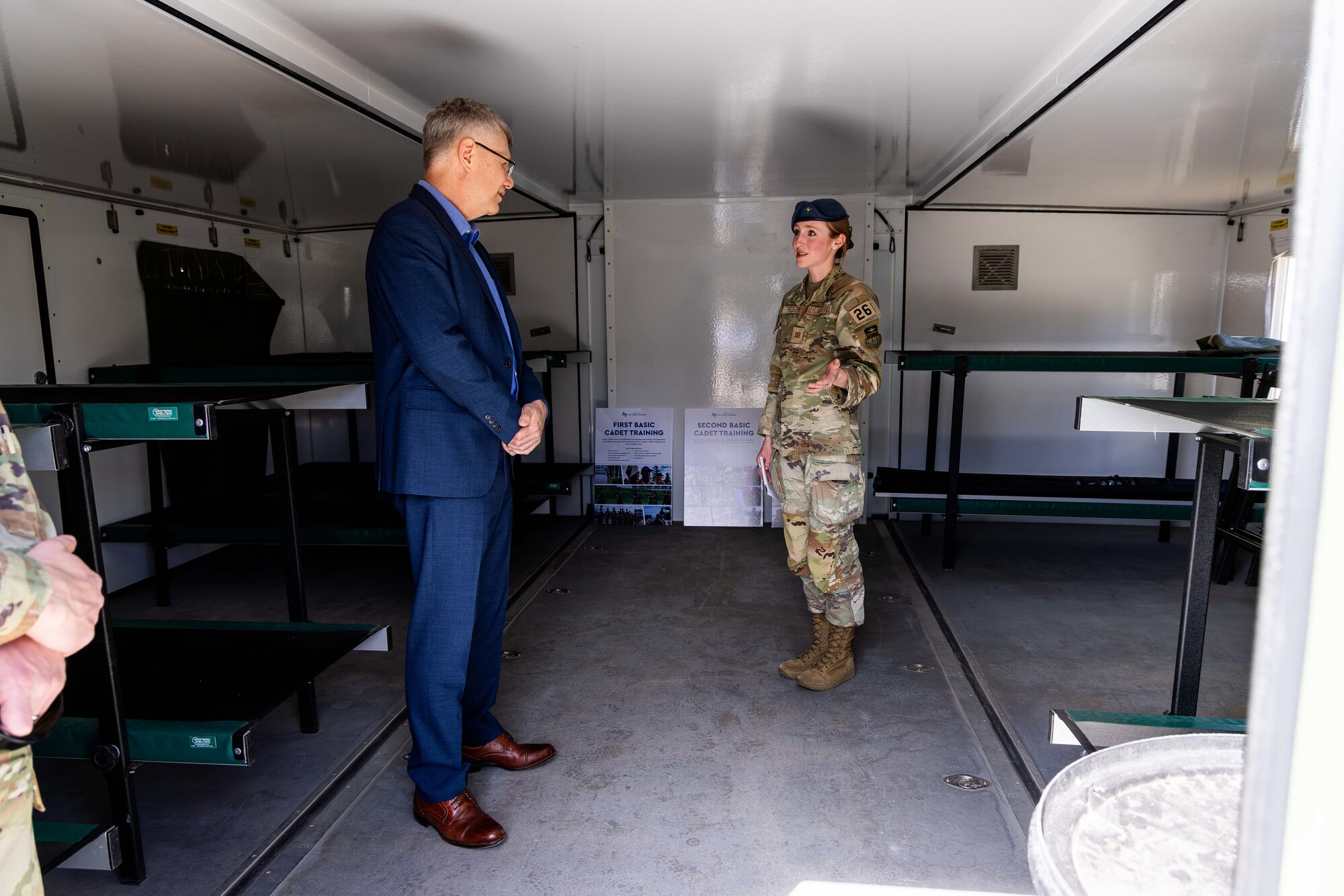 A Cadet briefs the Secretary of the Air Force inside a small work space.