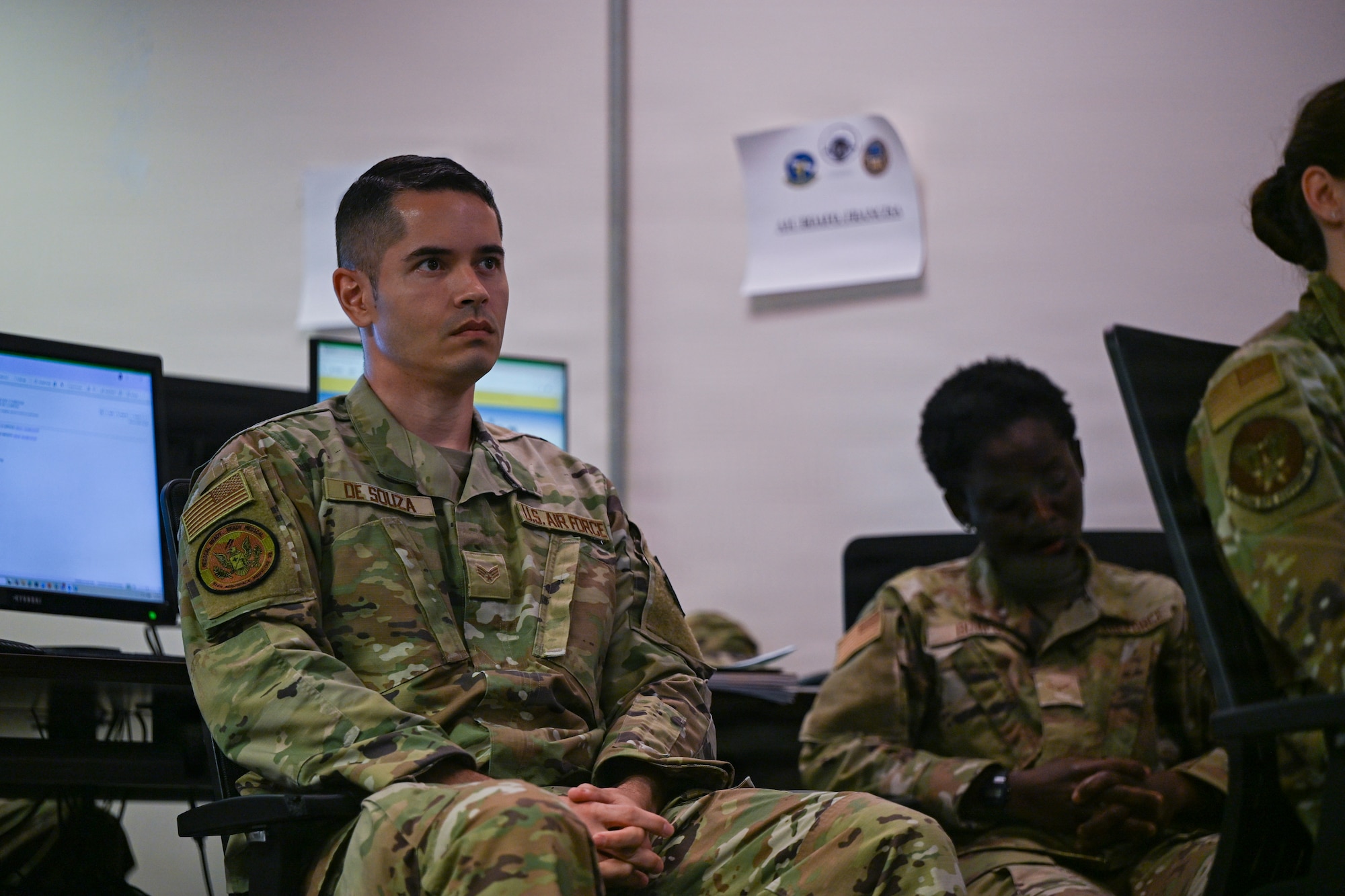 A person in military uniform is displayed in a classroom.
