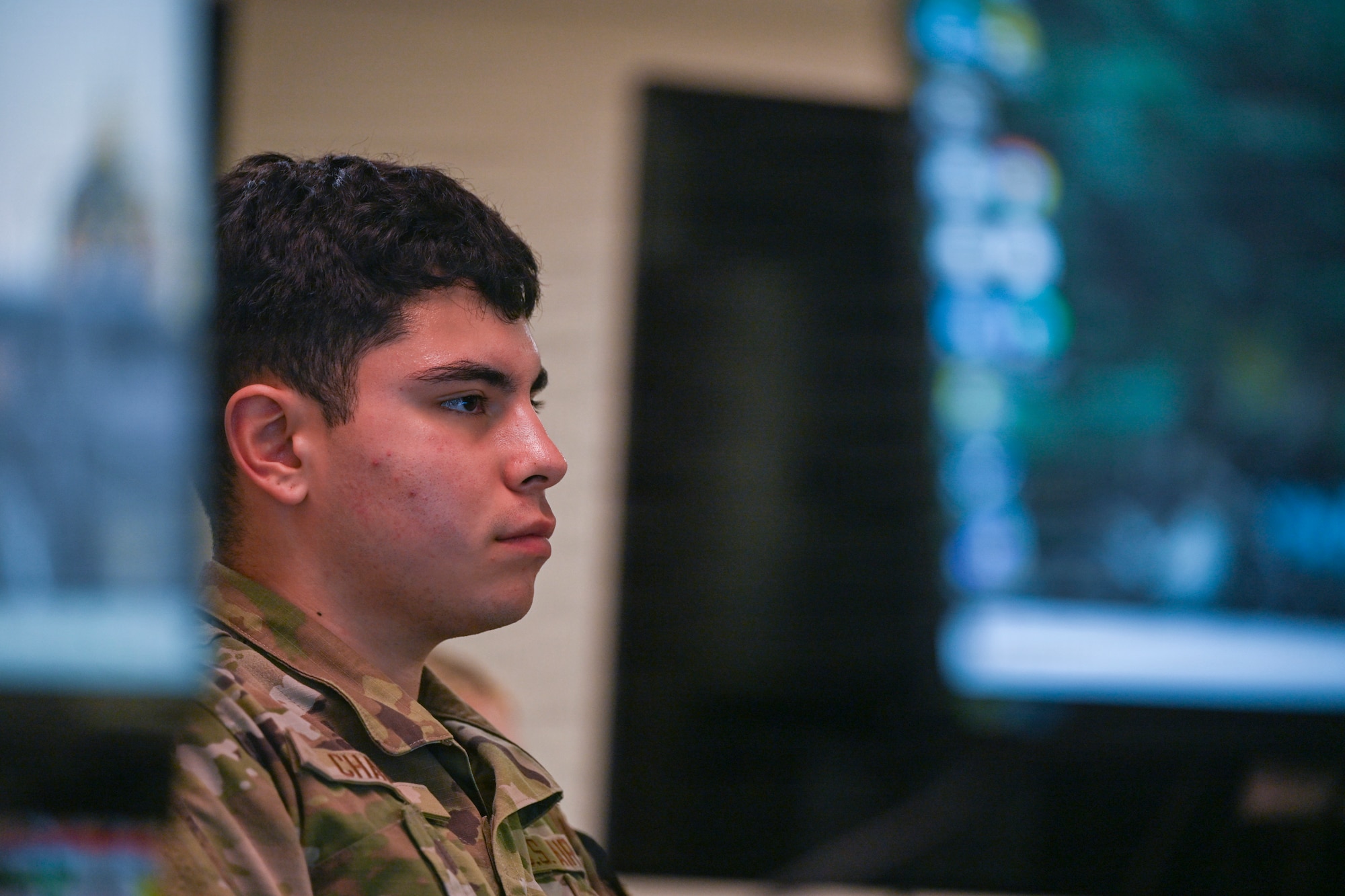 A person in military uniform is displayed in a classroom.
