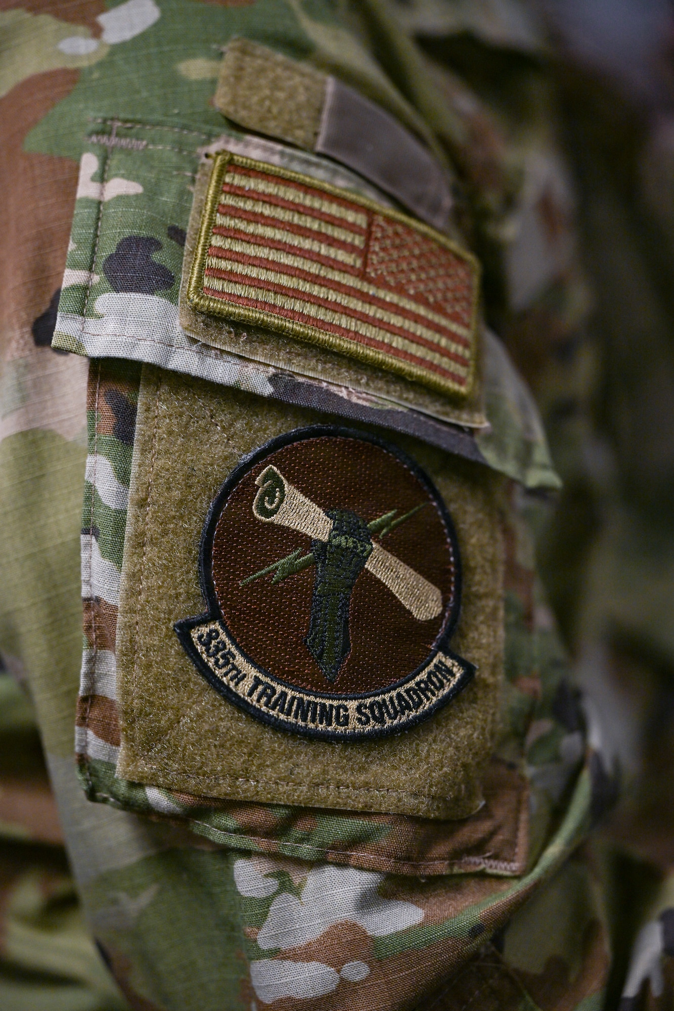 A person in military uniform is displayed in a classroom.