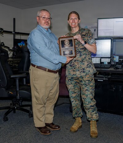 Jason Connerley, the dispatch supervisor of the Quantico Emergency Communication Center, left, and U.S. Marine Corps Col. Jenny Colegate, the commanding officer of Marine Corps Base Quantico, pose for a photo during Connerley’s award ceremony at the ECC on MCB Quantico, Virginia, April 27, 2026. The Public Safety Communications Center Supervisor of the Year Award is given for professional achievement and dedication, something that Connerley demonstrated throughout his time as an important asset of MCB Quantico and the ECC. (U.S. Marine Corps photo by Lance Cpl. Lynsee Avila-Ramirez)